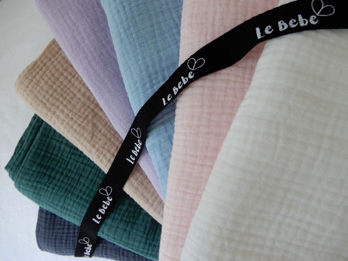 Rainbow of muslin wrap colours shown.