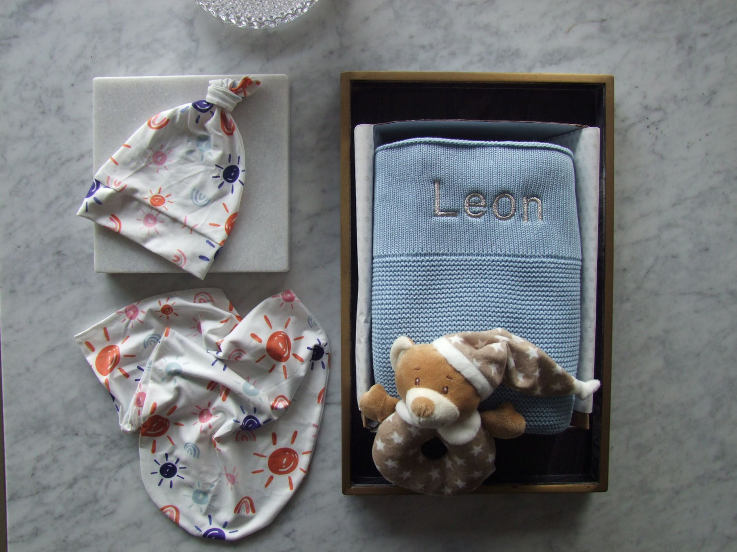 Blue knit baby blanket, can be beautifully personalised with baby name. Matching set knot beanie and baby body sock. This gift box also comes with a cute bear rattle.