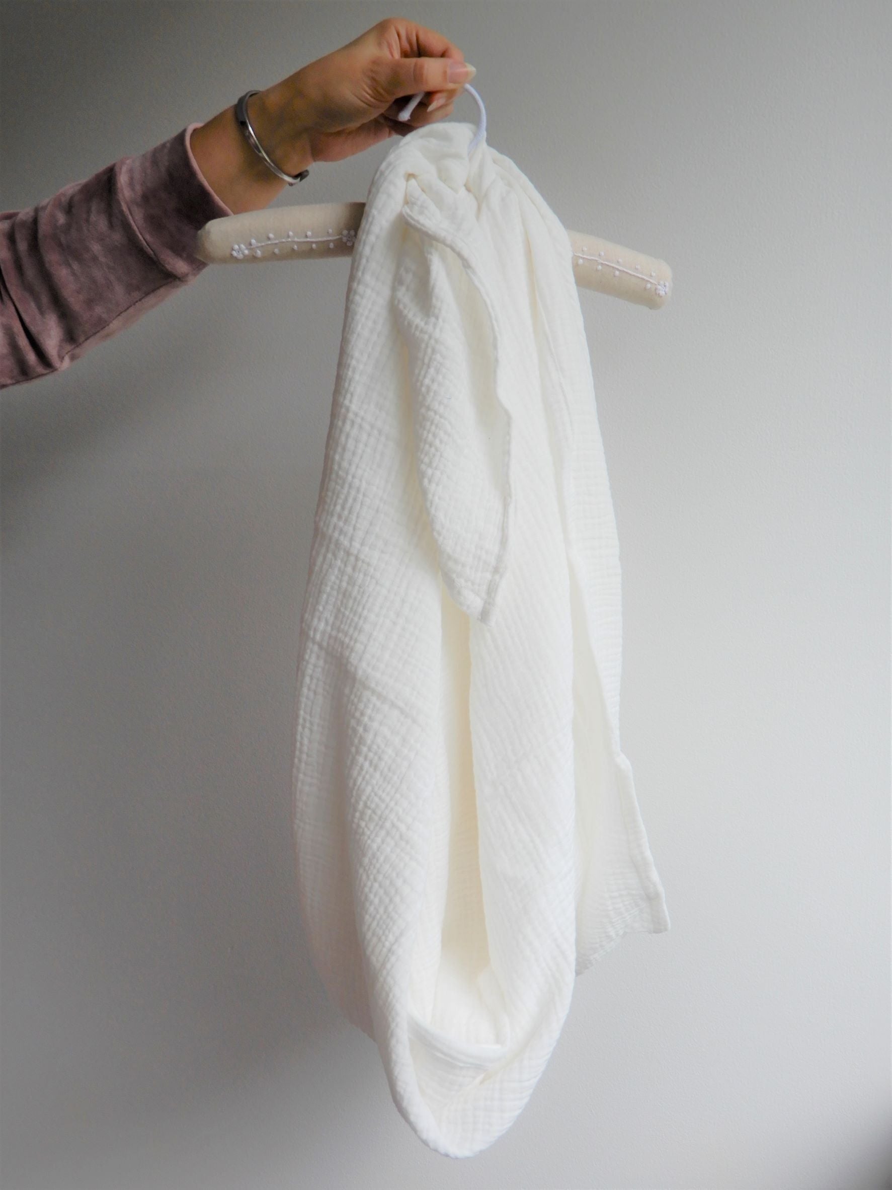 White muslin wrap open and held up