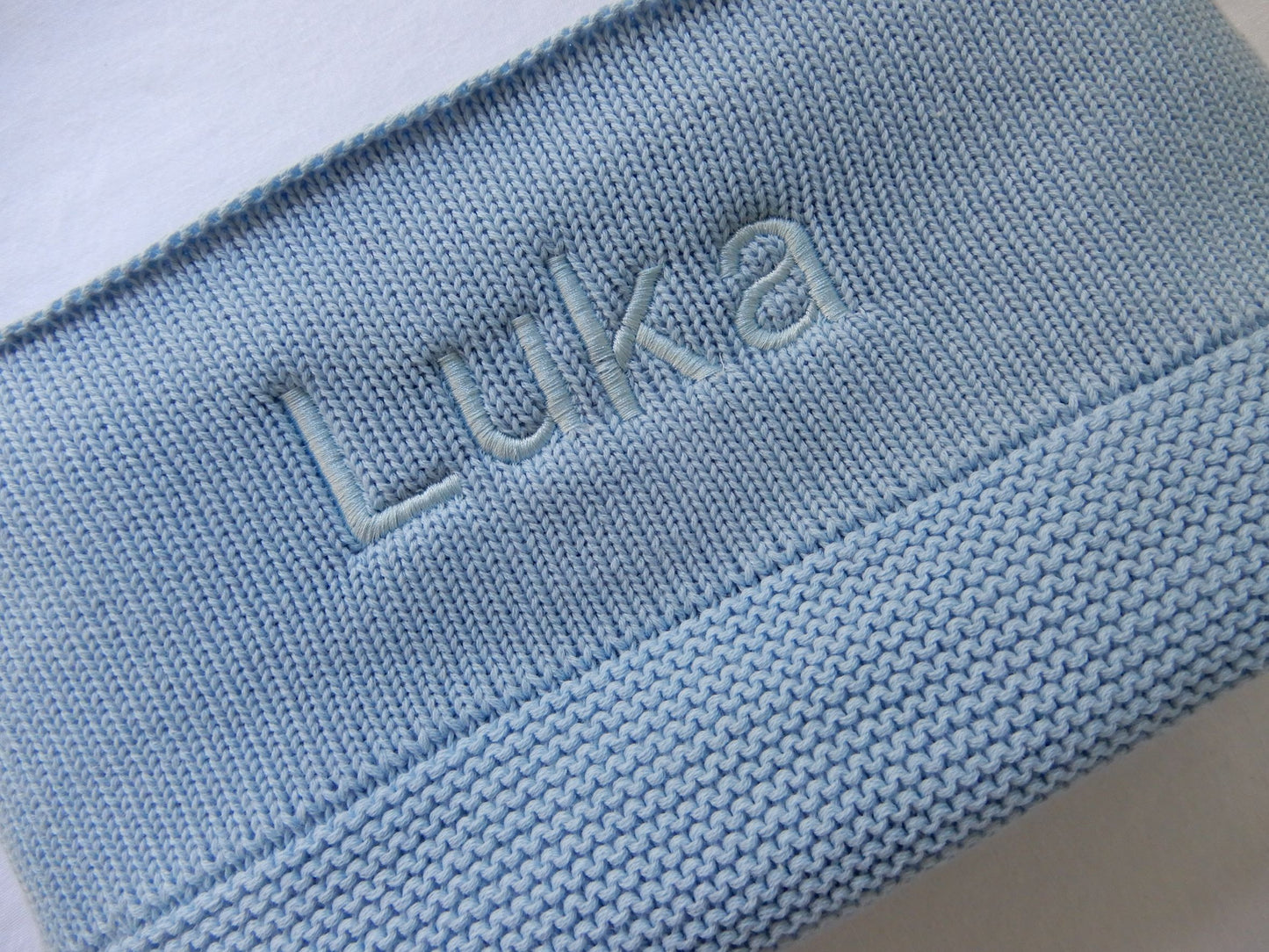 Blue Knit baby blanket, personalised with Light blue thread in bold font