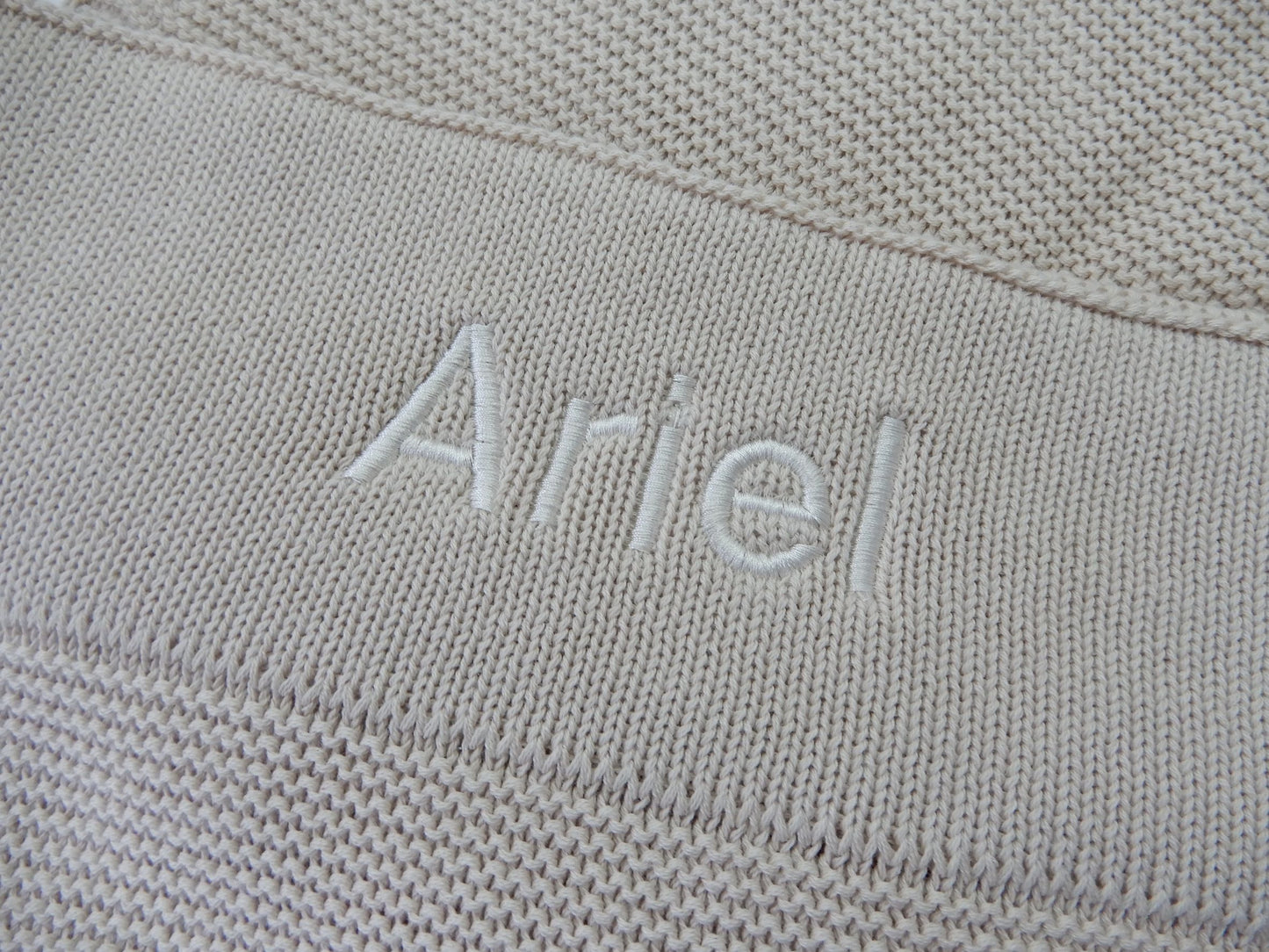 Stone baby knit blanket, personalised with white thread in bold font. 