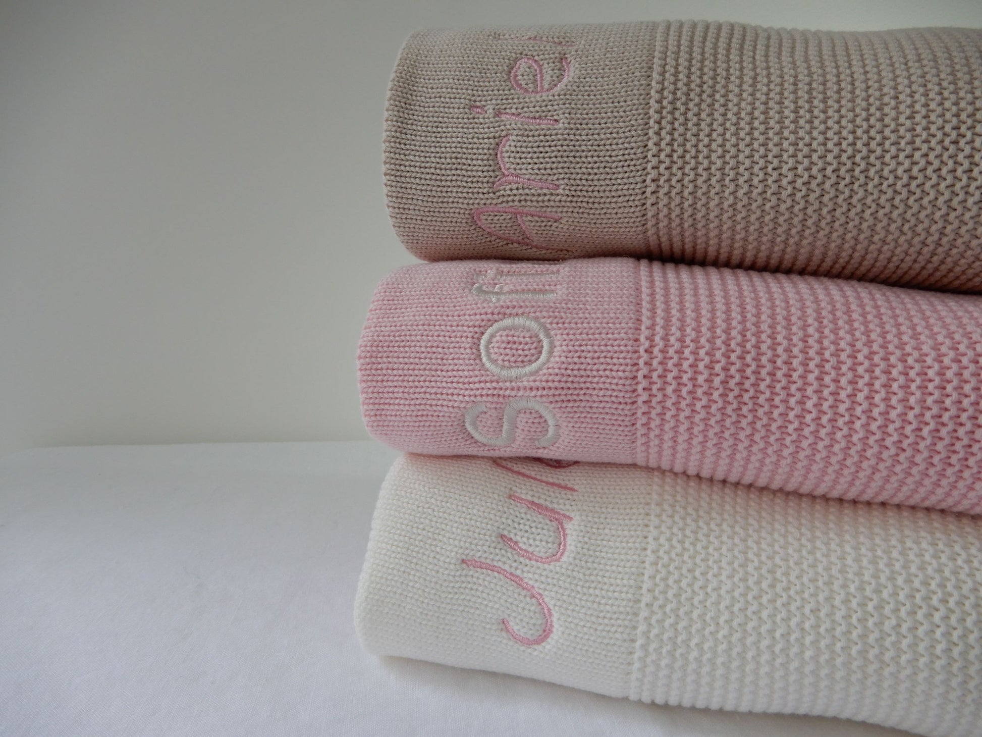 Stone, pink and white knitted blankets with personalisations