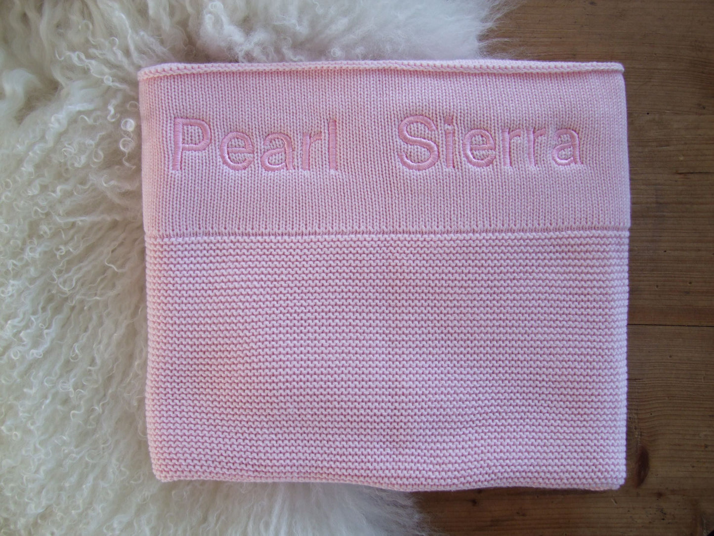 Pink knitted baby blanket. Personalisation with pink thread in bold