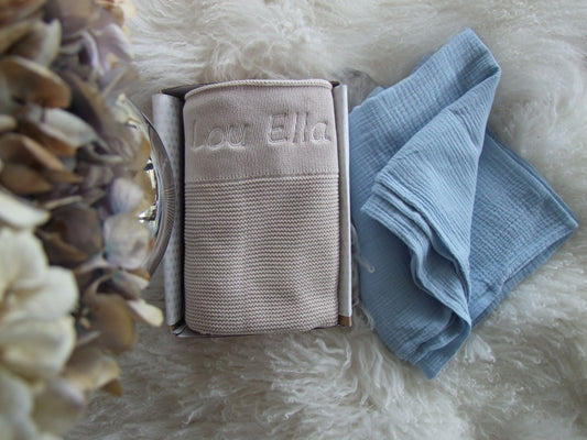 Stone baby knit blanket paired with blue muslin wrap. Both can be personalised to your liking and boxed for delivery.