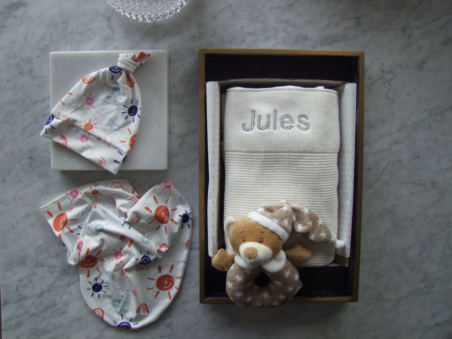 White knit baby blanket, can be beautifully personalised with baby name. Matching set knot beanie and baby body sock. This gift box also comes with a cute bear rattle.