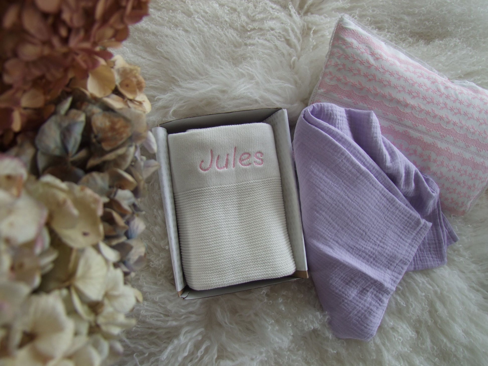 White baby knit blanket paired with purple muslin wrap. Both can be personalised to your choice.